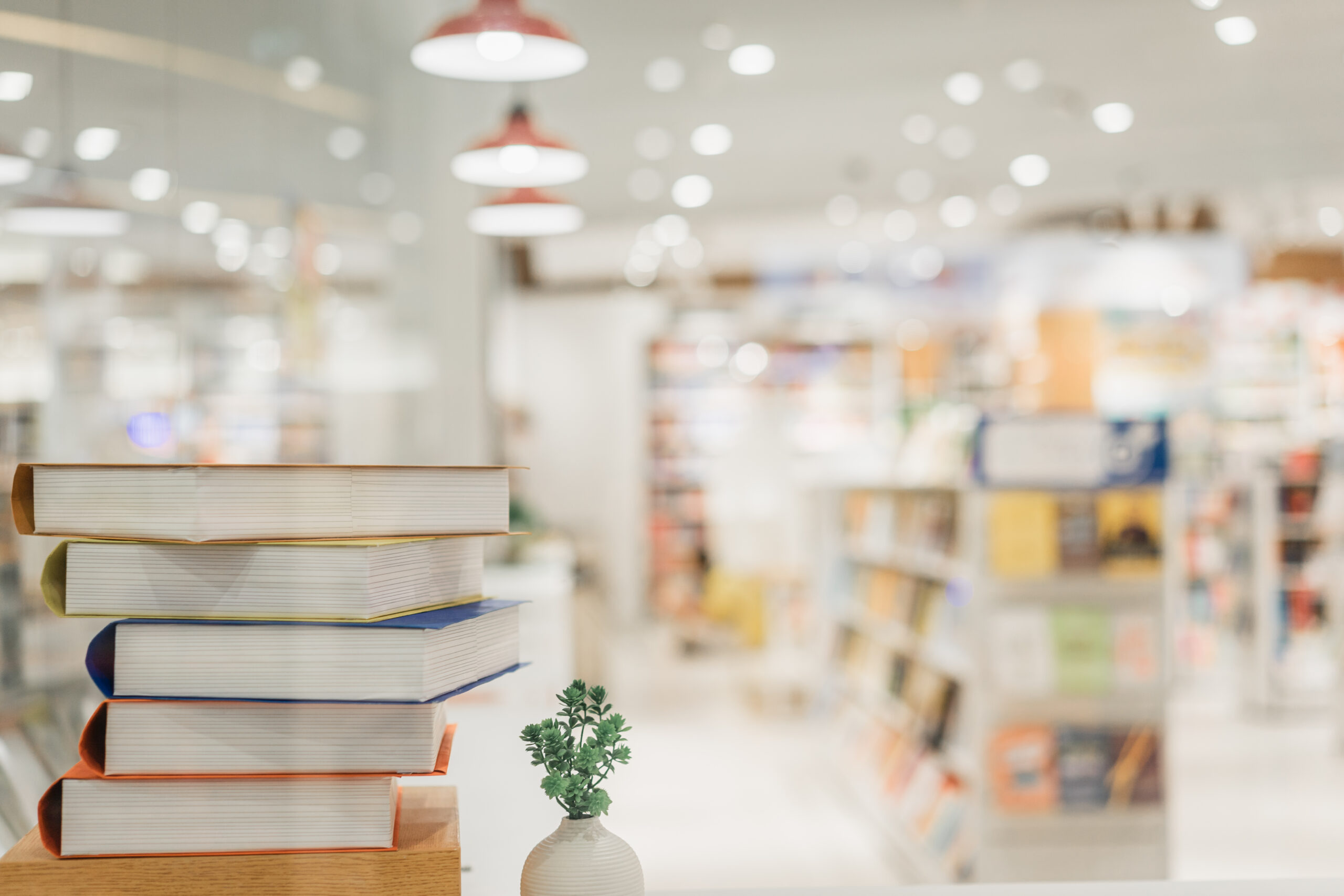 bibliotēkas telpas ar priekšplānā kaudzē novietotām grāmatām